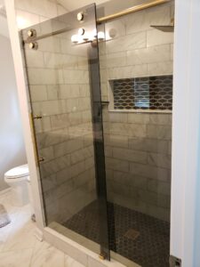 gray tiled shower with dark sliding glass doors