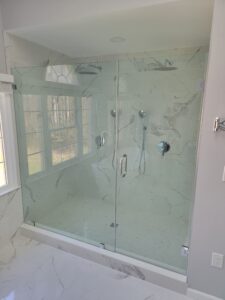 glass shower door in white marble bathroom