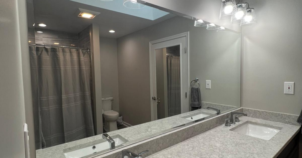 A newly installed custom glass bathroom mirror by The Glass Guys.